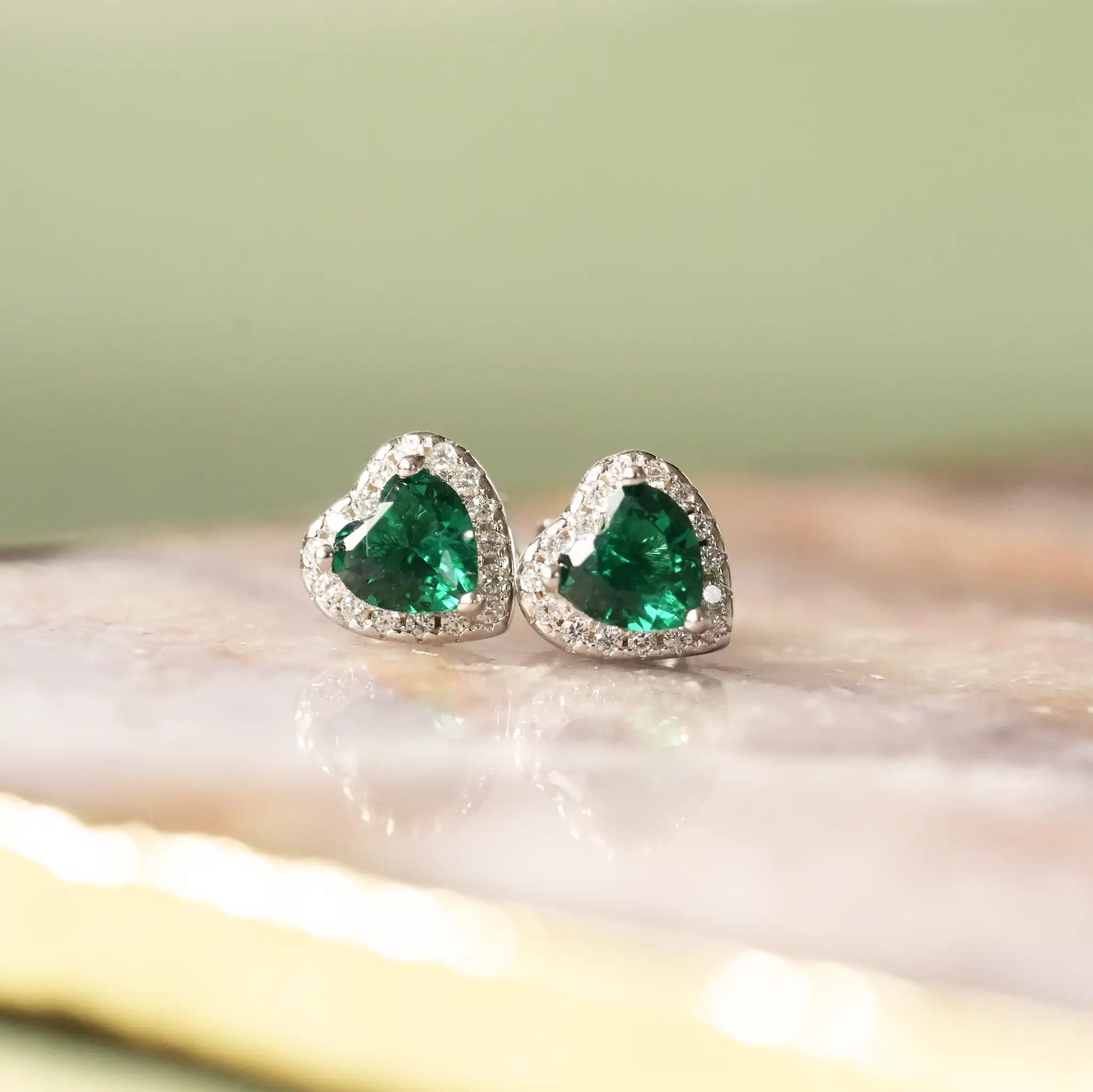Emerald birthstone earrings, green stones in a heart with cubic zirconia around them perfect for May birthdays