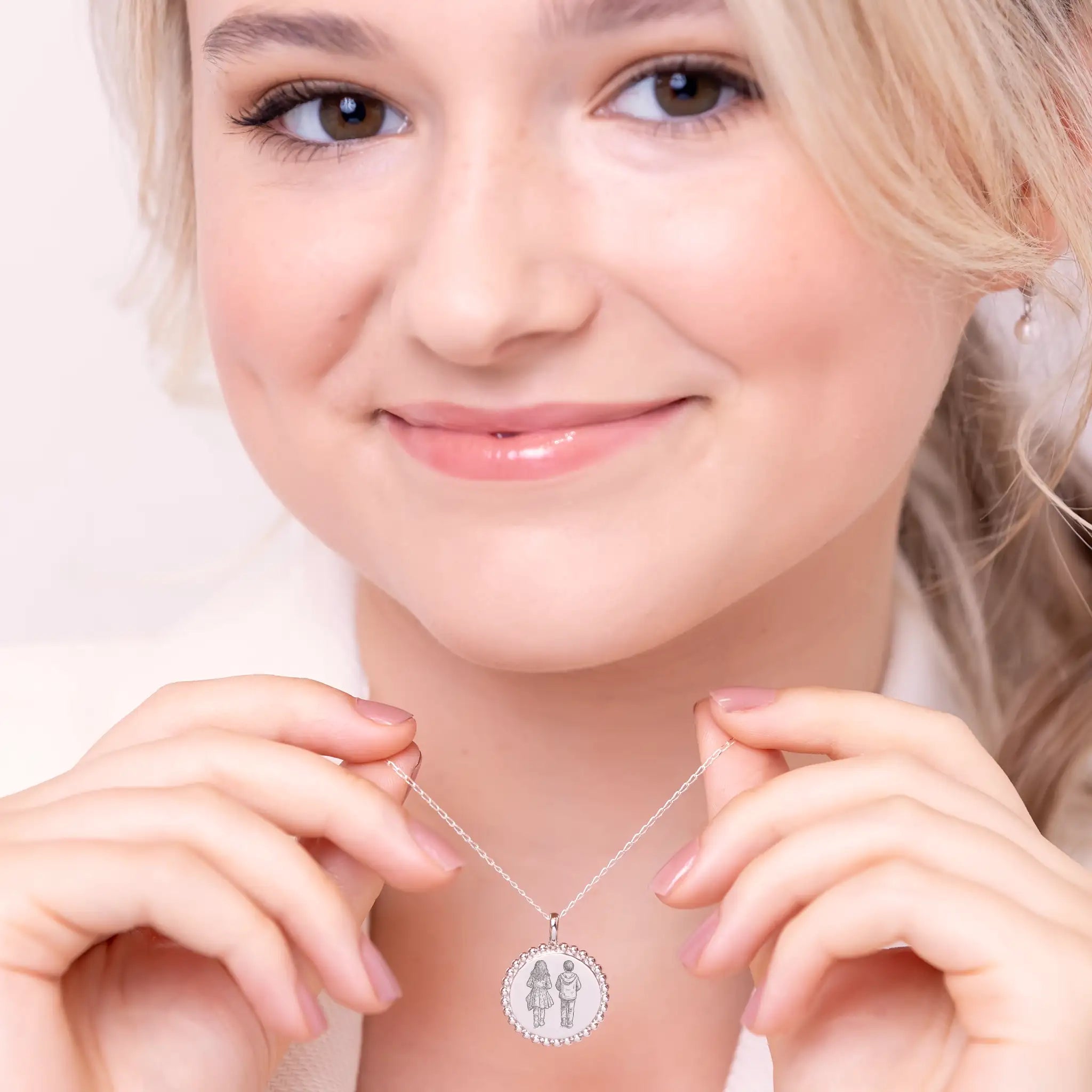 Custom photo illustration pendant being worn as a necklace, showing 2cm sterling silver disc with detailed laser engraving